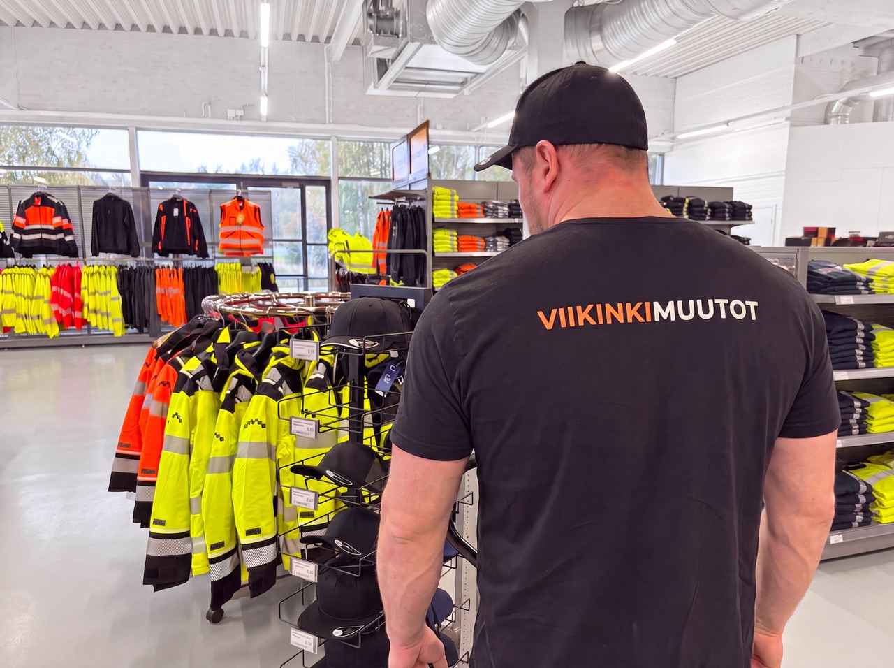 Viikinkimuutot-muuttaja liiketilassa työvaatemyymälän kalusteiden äärellä